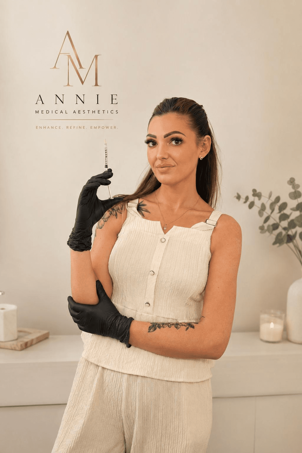 Annie, Registered NMC Nurse, in a cream top and black clinical gloves holding a syringe in her Dereham treatment room.